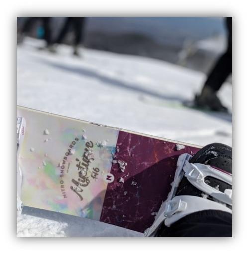 A snowboarder sits at the top of a slope
